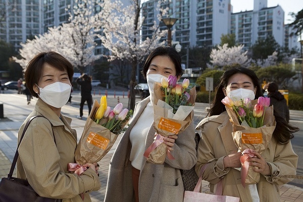 꽃다발을 전달받은 서울의료원 직원들이 환하게 웃고 있다.